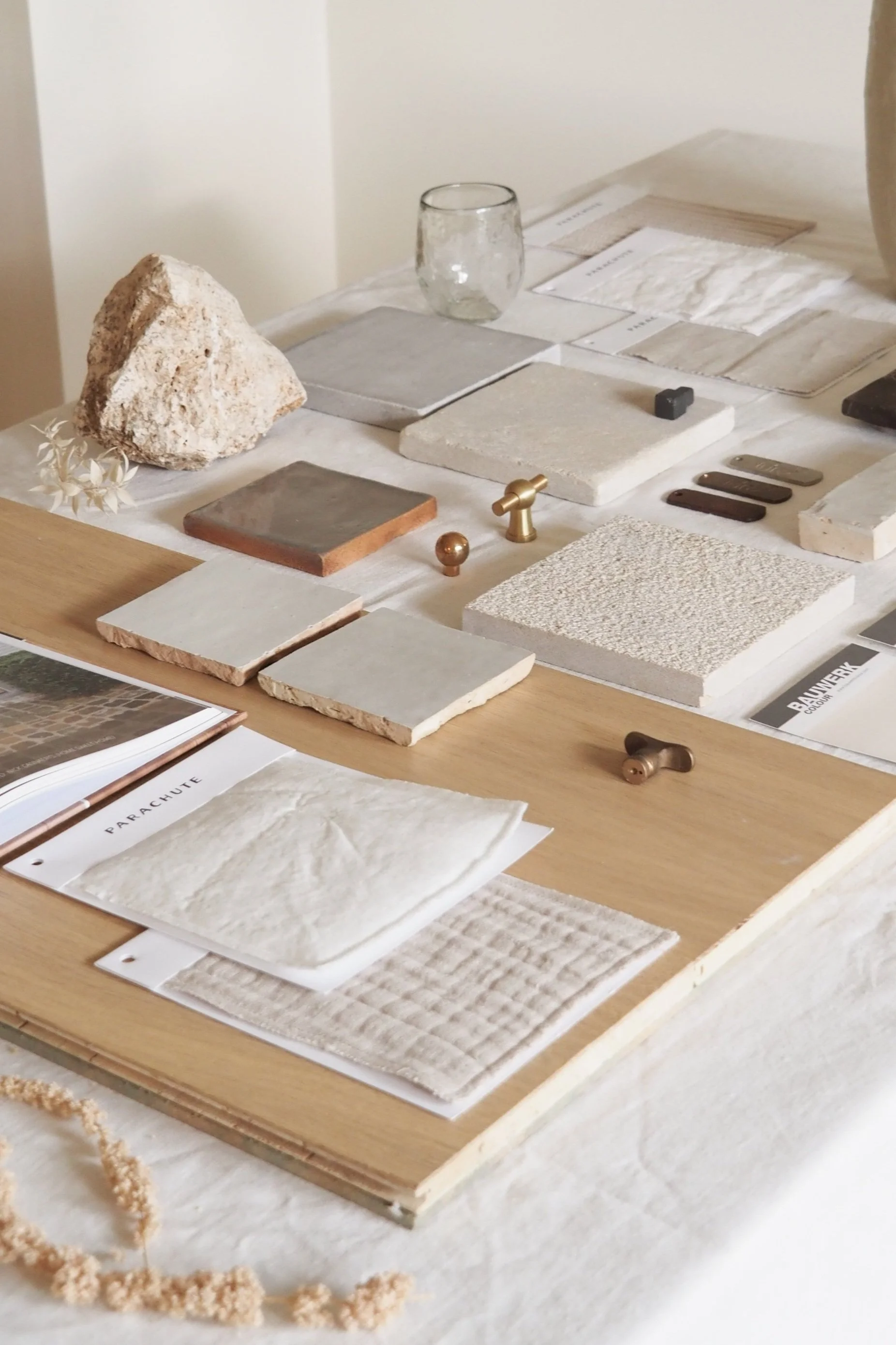 Moodboard with lots of textures and unique materials such ass copper and bronze handles;  wood and fabric samples and stone tiles.