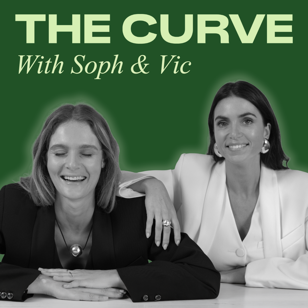 Black and white photo of two women, one with eyes closed smiling, and the other smiling at the camera, sitting together at a table with a green background. Text at the top says 'The Curve With Soph & Vic'.