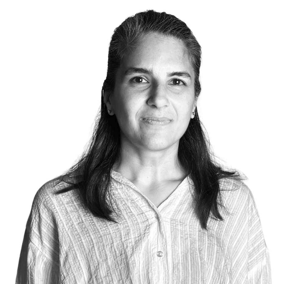 Black and white portrait of a woman with long dark hair, wearing a light-colored, button-up shirt, against a plain background.