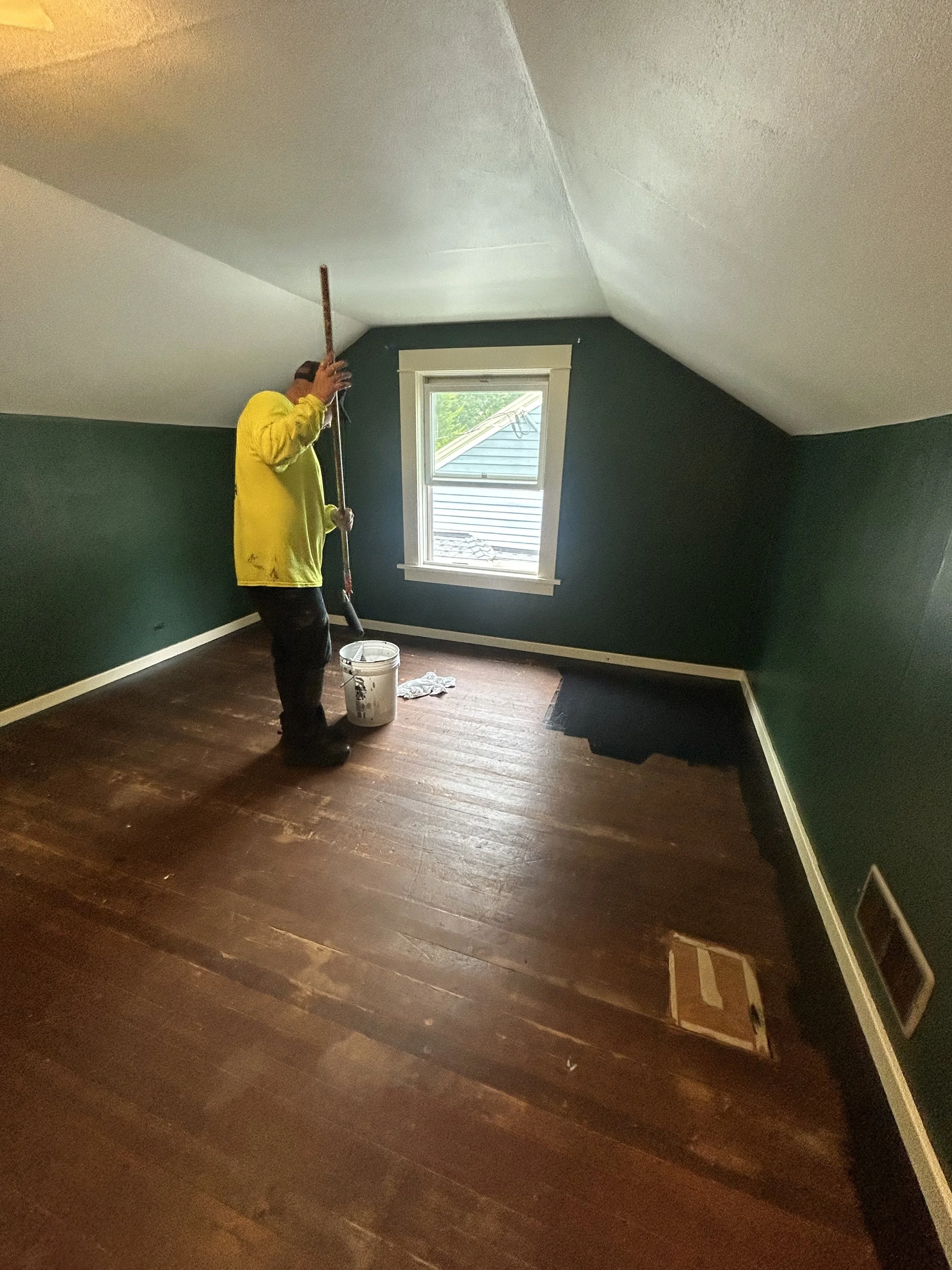 Professional painter applying Sherwin‑Williams Porch and Floor Enamel during an interior floor painting project in East Portland.