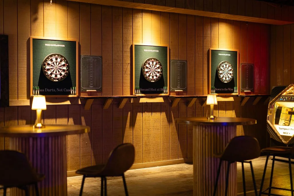 Three dartboards and lounge seating prepared for event guests.