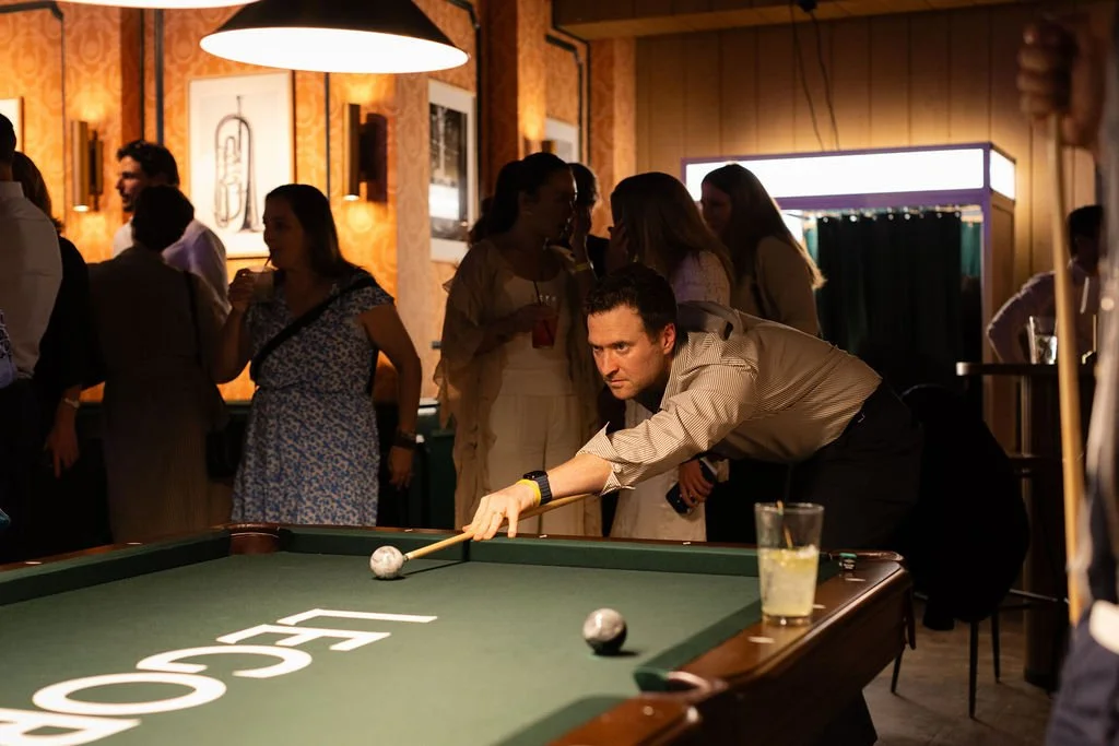 Guests gathering around a Legora-branded pool table.