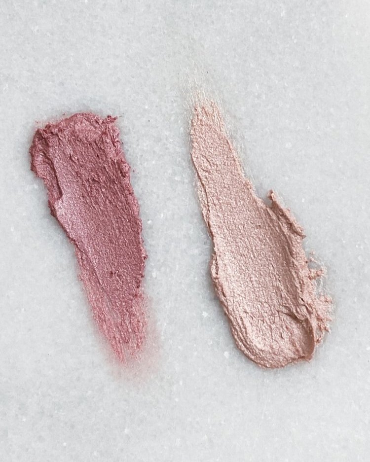 a swipe of both a darker and lighter pink shimmer balm on a white marble surface