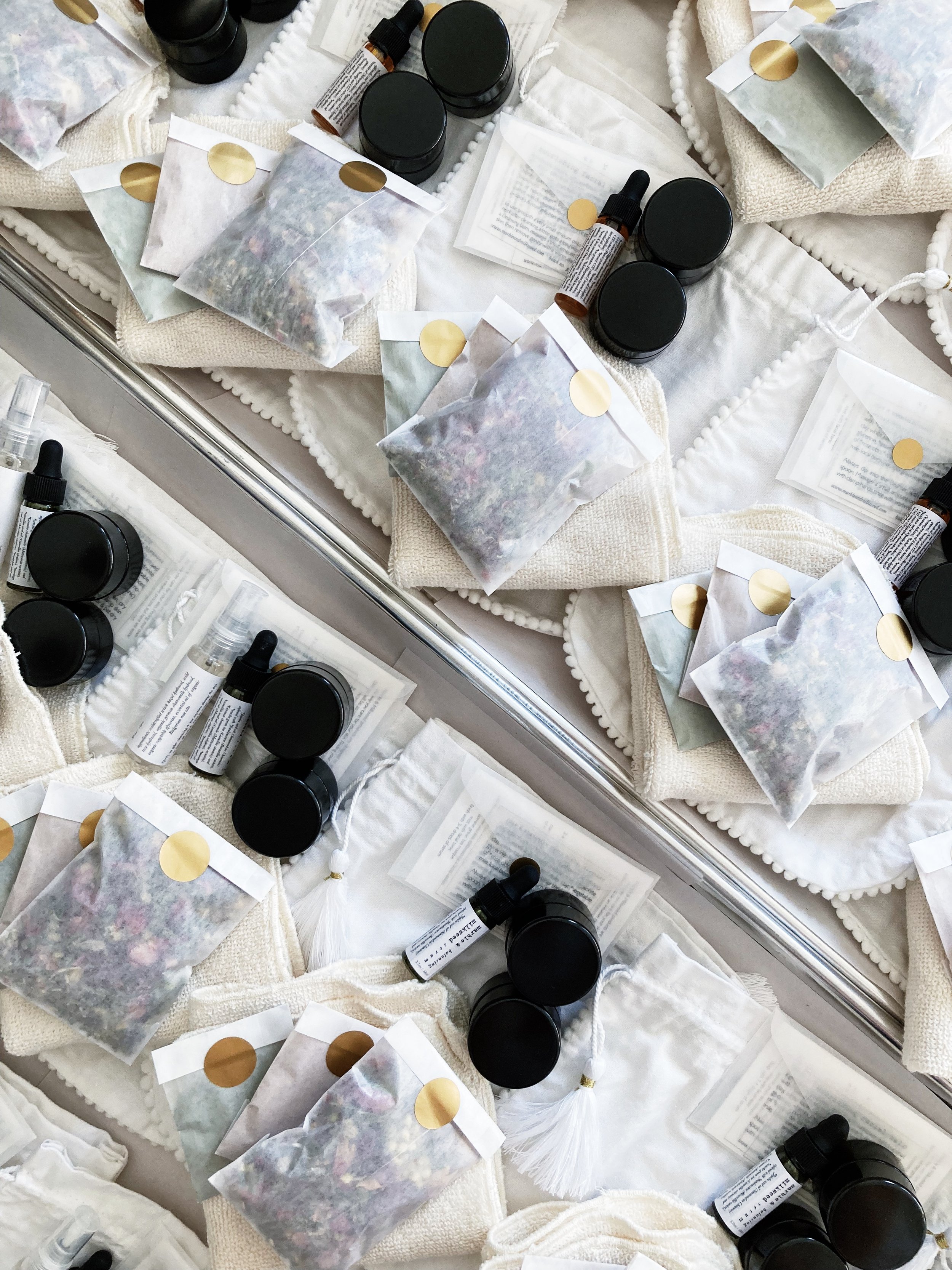 small white envelopes and black jars on a tray in the process of being packed up