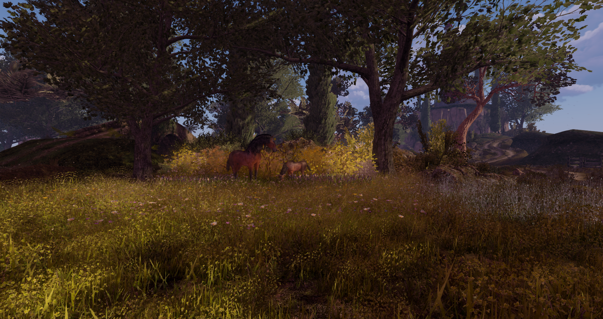 A serene Second Life landscape design featuring horses grazing in a wildflower meadow beneath mature trees, surrounded by layered greenery, rolling terrain, and a peaceful nature-inspired setting.