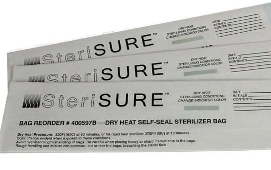 Three SteriSURE dry heat self-seal sterilizer bags stacked on top of each other, with instructions and details printed on them.