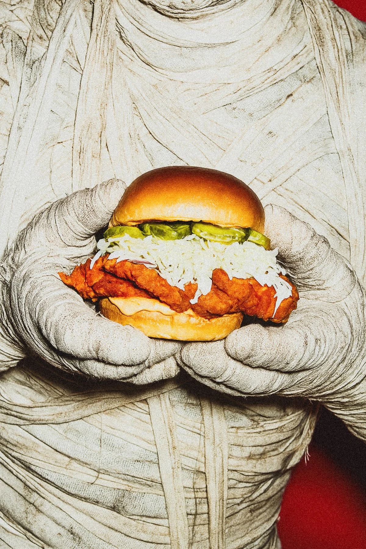 A person in a sketch-style outfit holding a fried chicken sandwich with pickles, coleslaw, and sandwich bun.