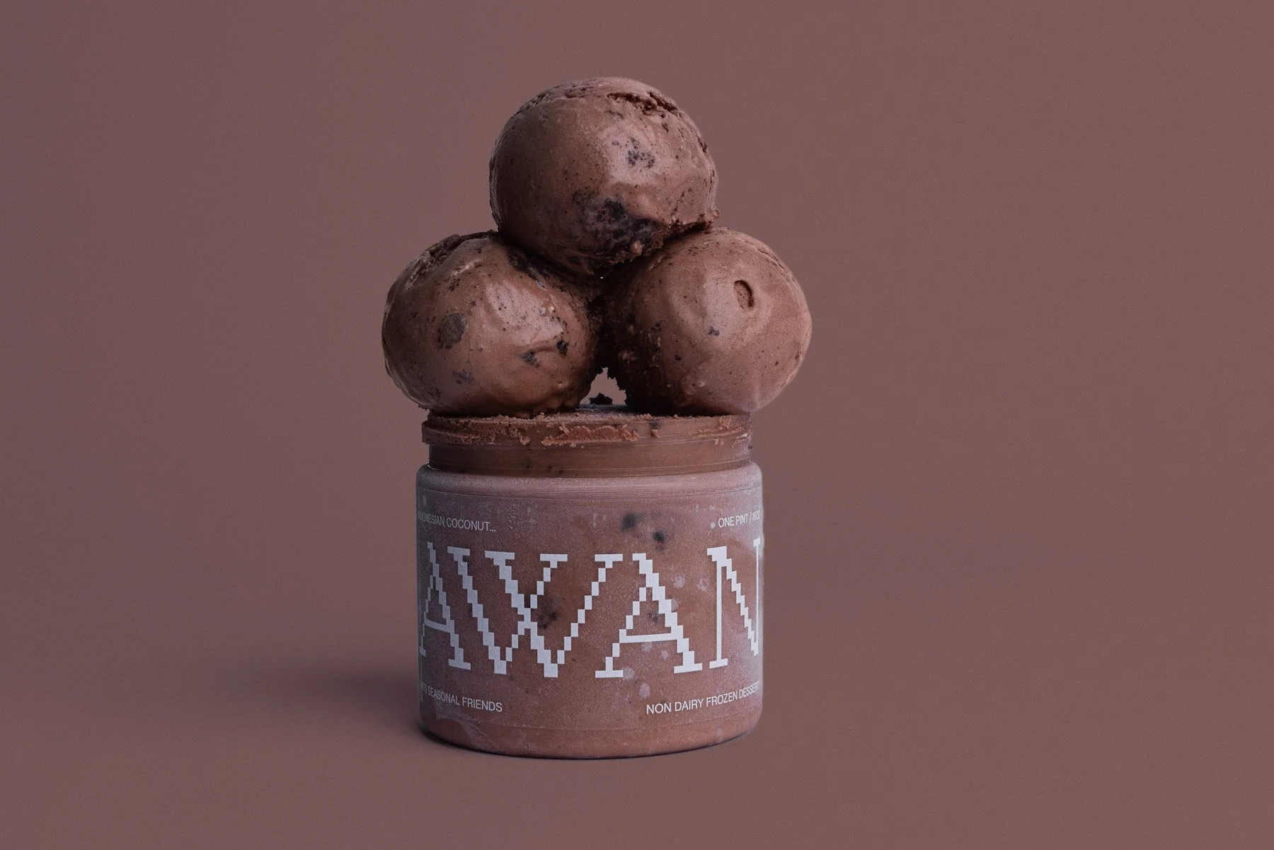 Three scoops of chocolate ice cream with chocolate chips stacked on top of a container of non-dairy frozen dessert with a pinkish-brown background.