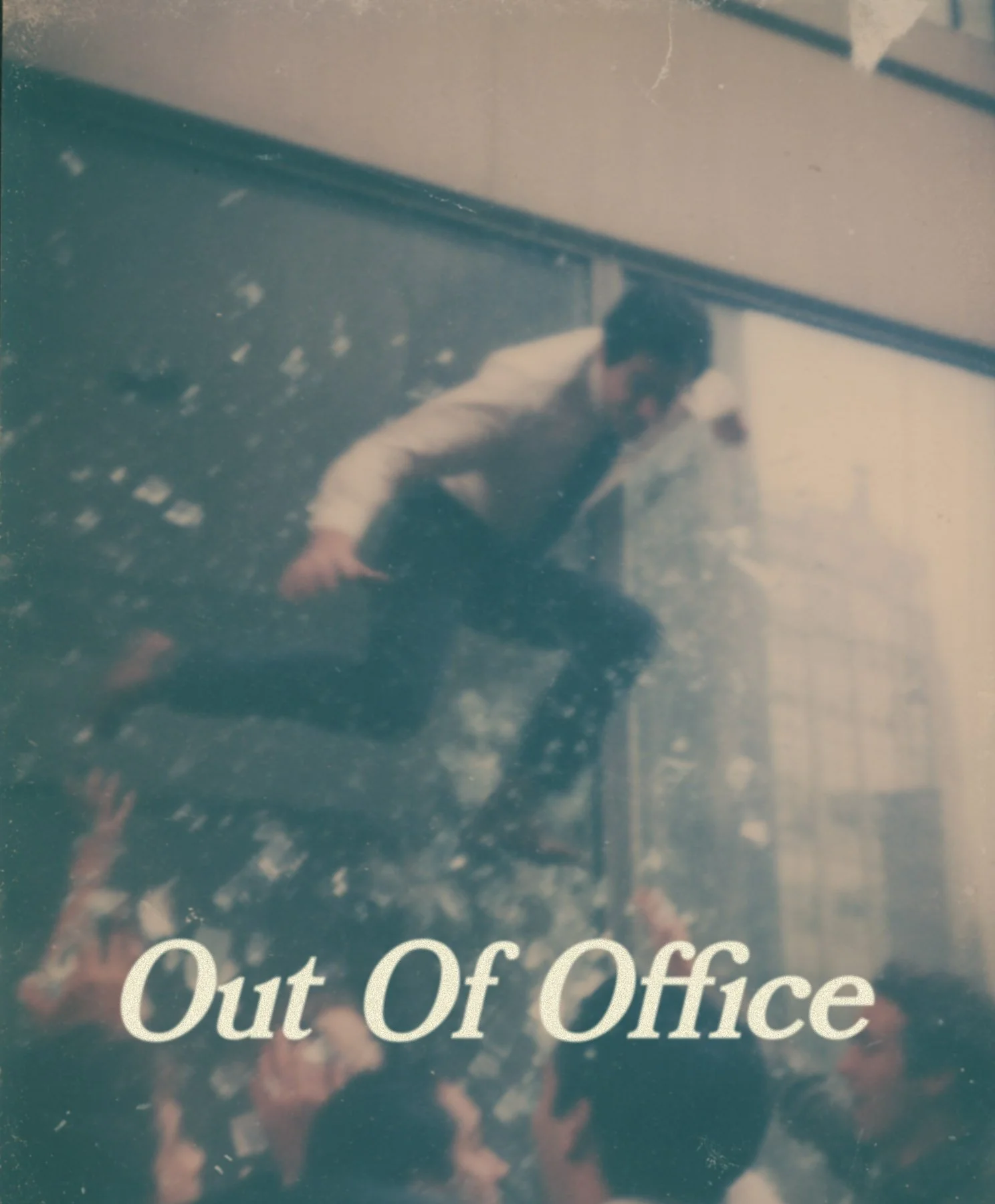 A person in a white shirt appears to be walking out of an office, reflected in a frosted glass window that has the words "Out Of Office" written on it.