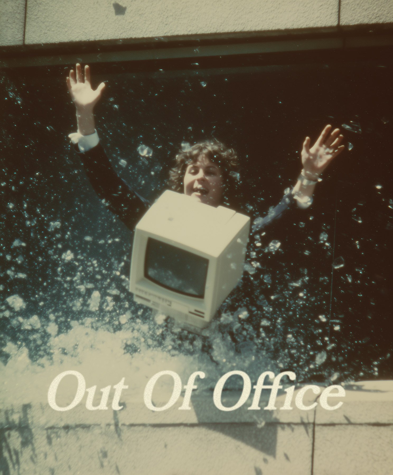 Broken and abandoned computer monitor lying on the ground surrounded by dirt and debris, with a sign behind it reading 'Out Of Office'.