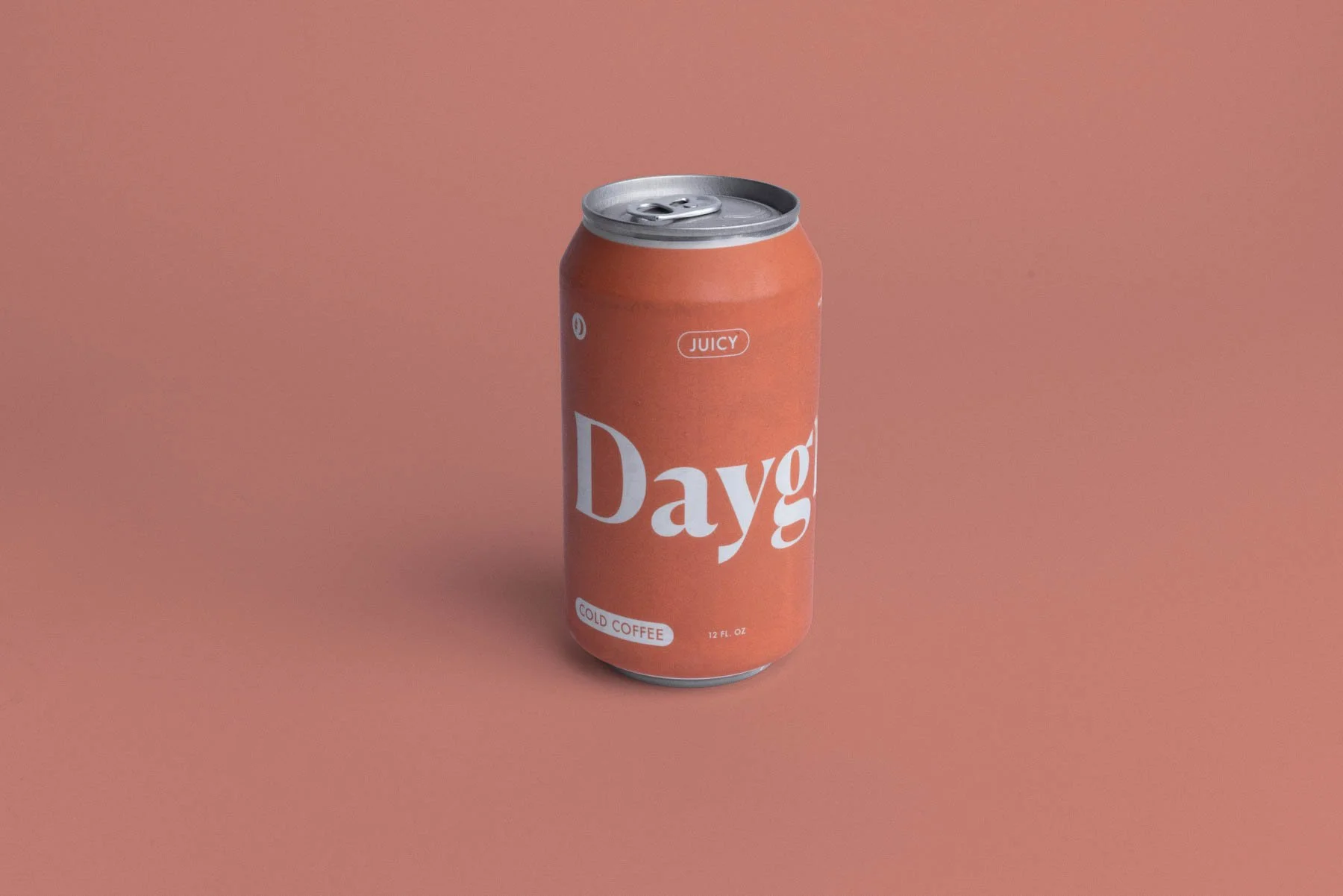 A can of cold coffee with a pink label that says "Dayg" and "Juicy" with a background of solid pink.