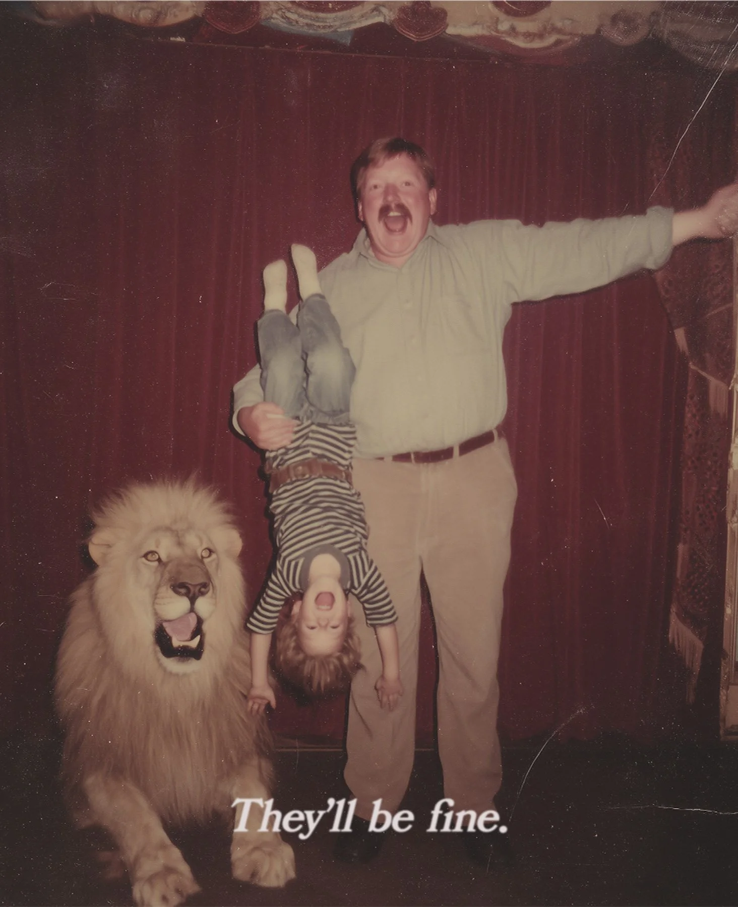 A man holding a young child upside down with another child standing upside down between the man and the child, a lion statue on the floor, and red curtains in the background. The caption at the bottom reads, 'They'll be fine.'