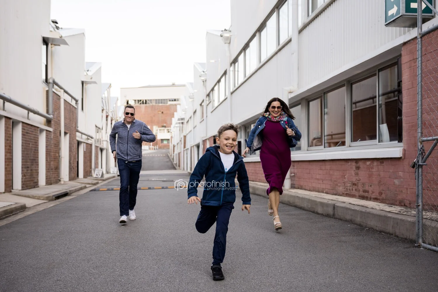 Parents and son running towards the camera during family photo session at Sub Platypus Base in North Sydney