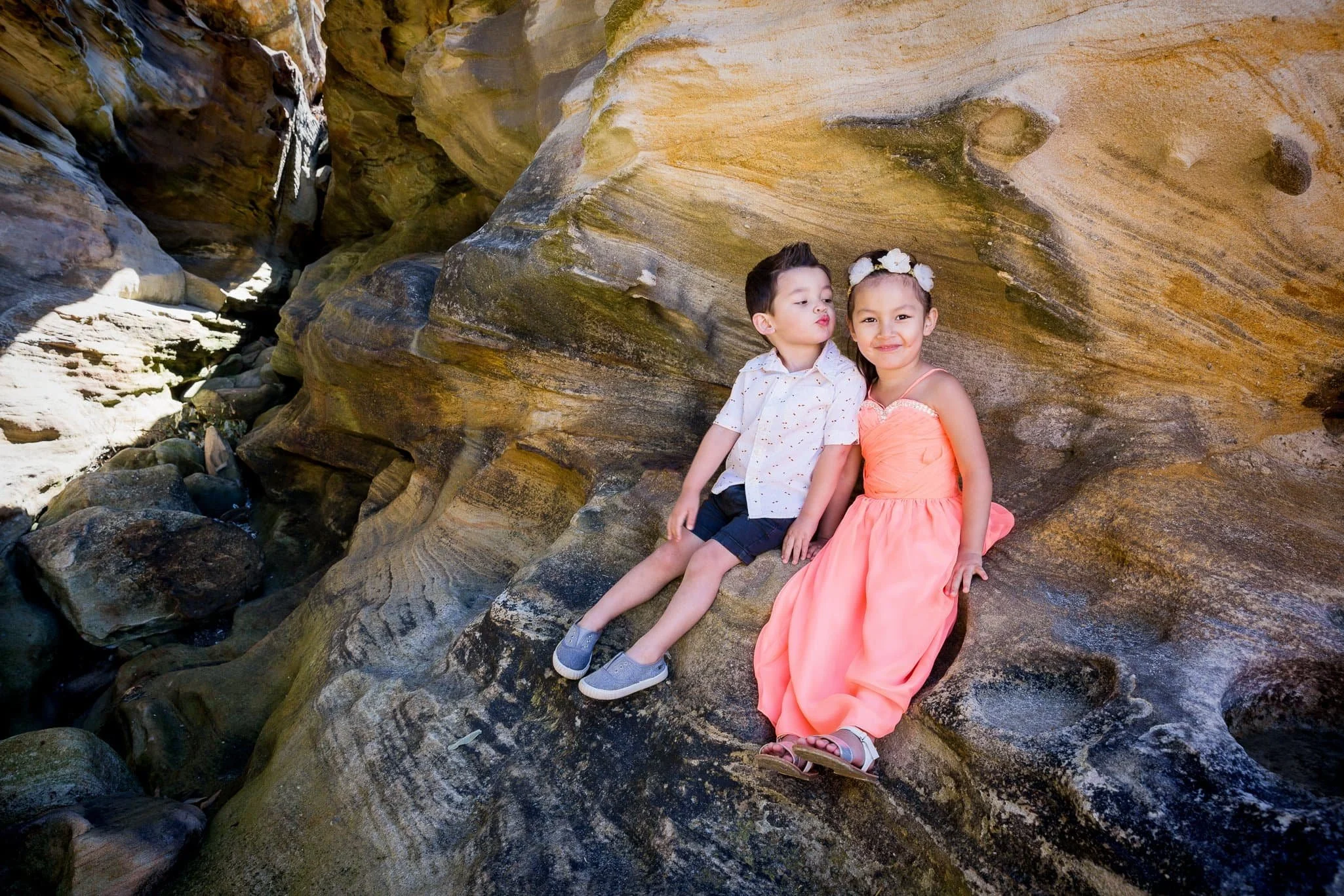 children playing and laughing during a candid beach photo session at Balmoral Beach, Sydney, with natural light and relaxed expressions