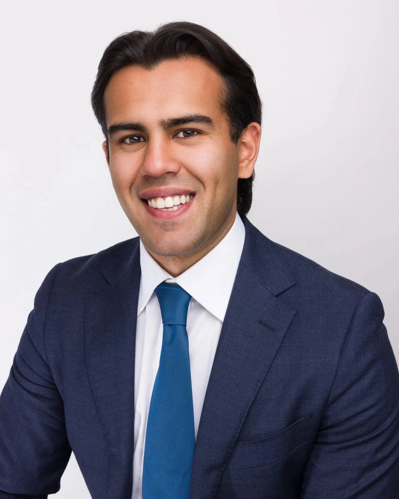 Professional headshot of male university student in navy suit for investment banking internship