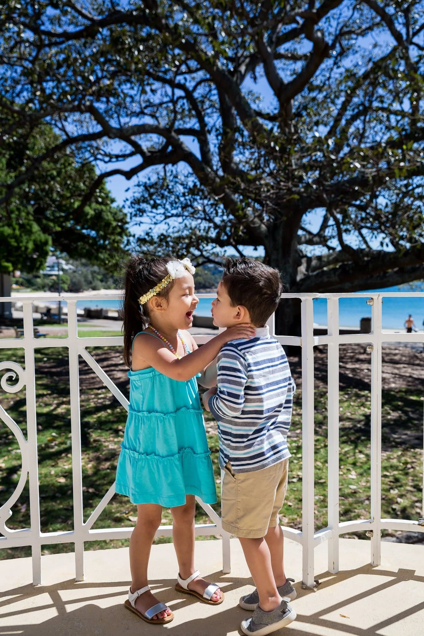 children playing and laughing during a candid beach photo session at Balmoral Beach, Sydney, with natural light and relaxed expressions