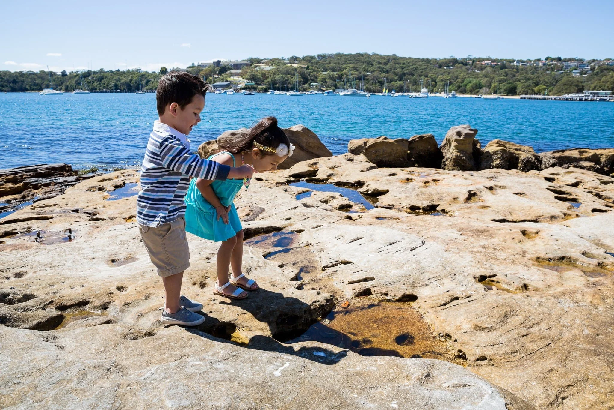 children playing and laughing during a candid beach photo session at Balmoral Beach, Sydney, with natural light and relaxed expressions