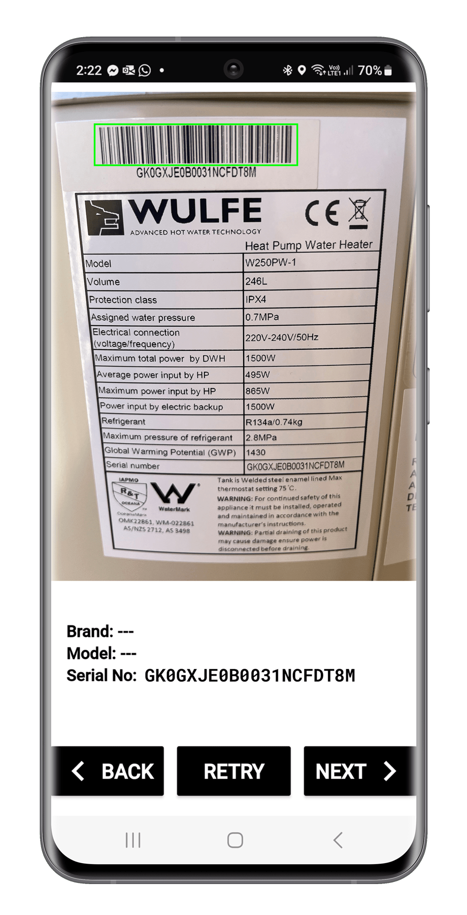 Smartphone screen showing barcode and product label for a WULFE heat pump water heater, model W250PW-1, with serial number GK0GXJEOB0031NCFDT8M.
