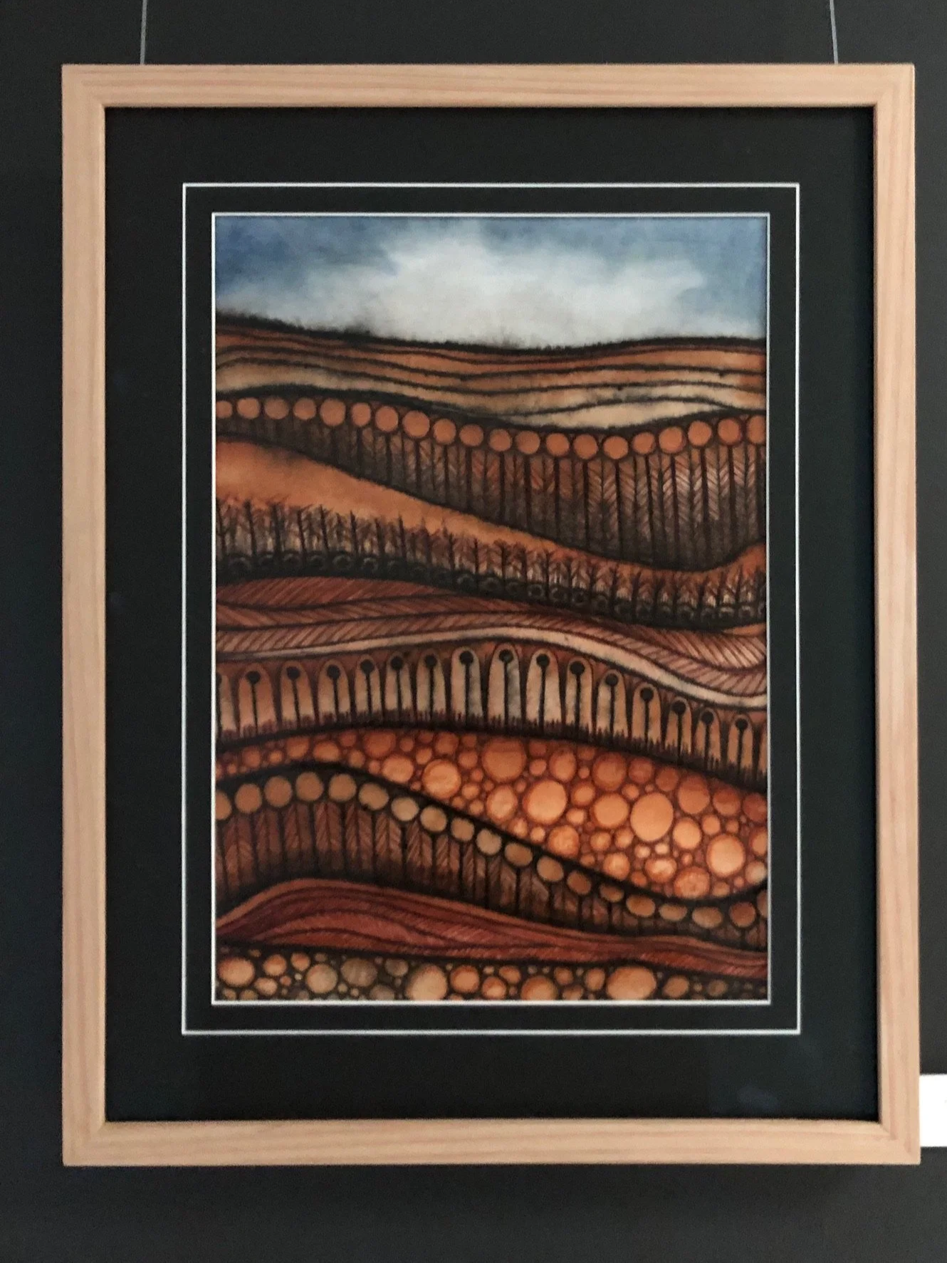 Painting of rolling hills with trees, abstract patterns, and circles in warm earth tones