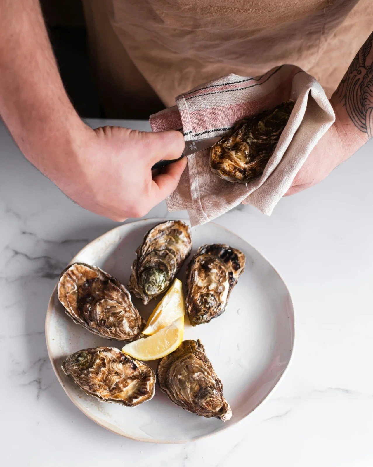 Oysters and marble: a pairing of elegance and sophistication. The smooth, cool surface of marble complements the briny richness of oysters, creating a dining experience that's as luxurious as it is delicious. Indulge in this exquisite combination and