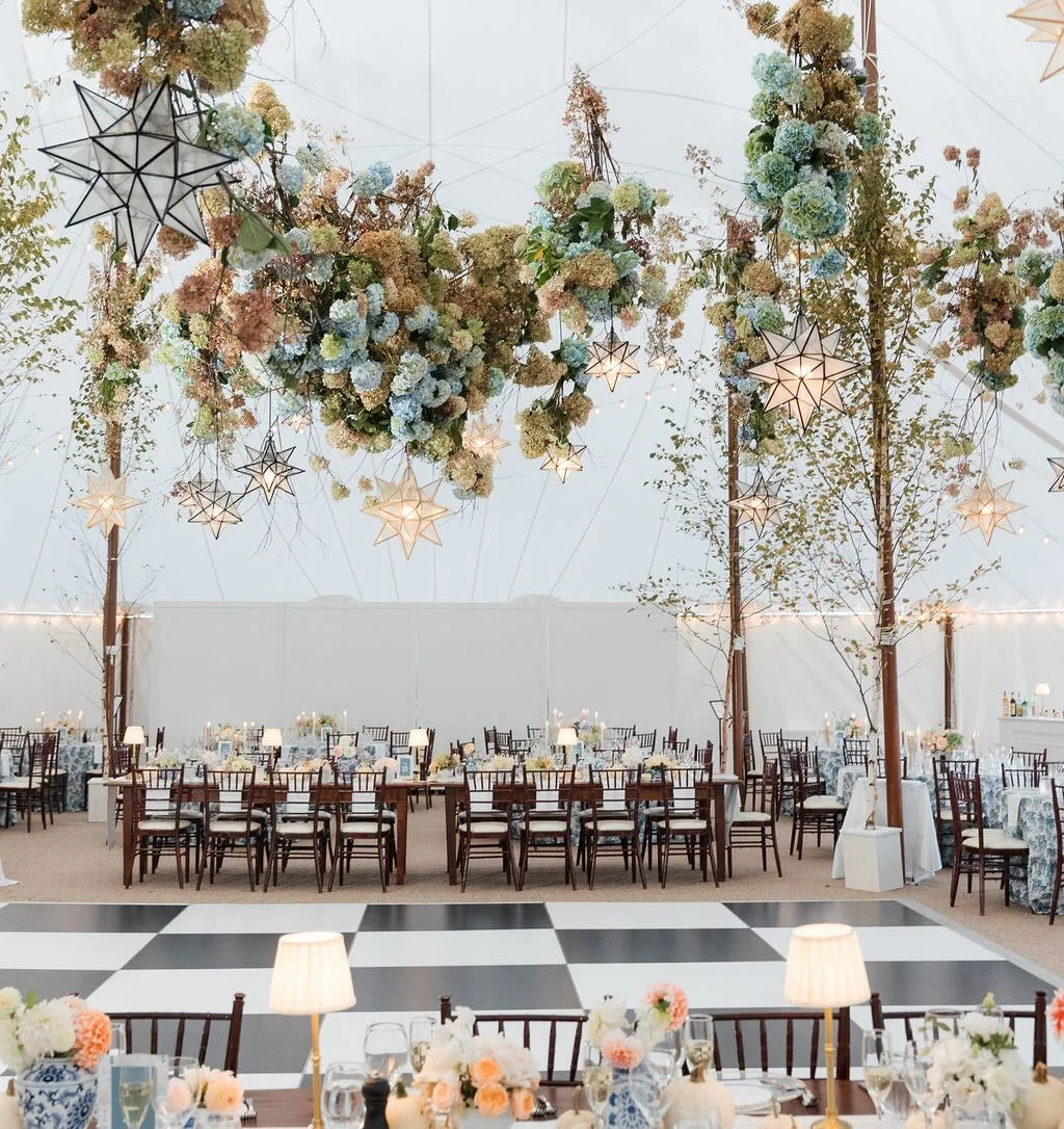 A tent can feel vast and cavernous at times.  And as much as we love a good tented space, we also know that your tent needs to feel visually warm and inviting.  A floral ceiling and lighting install made this 300 person seated tent twinkle!✨ 

Venue: