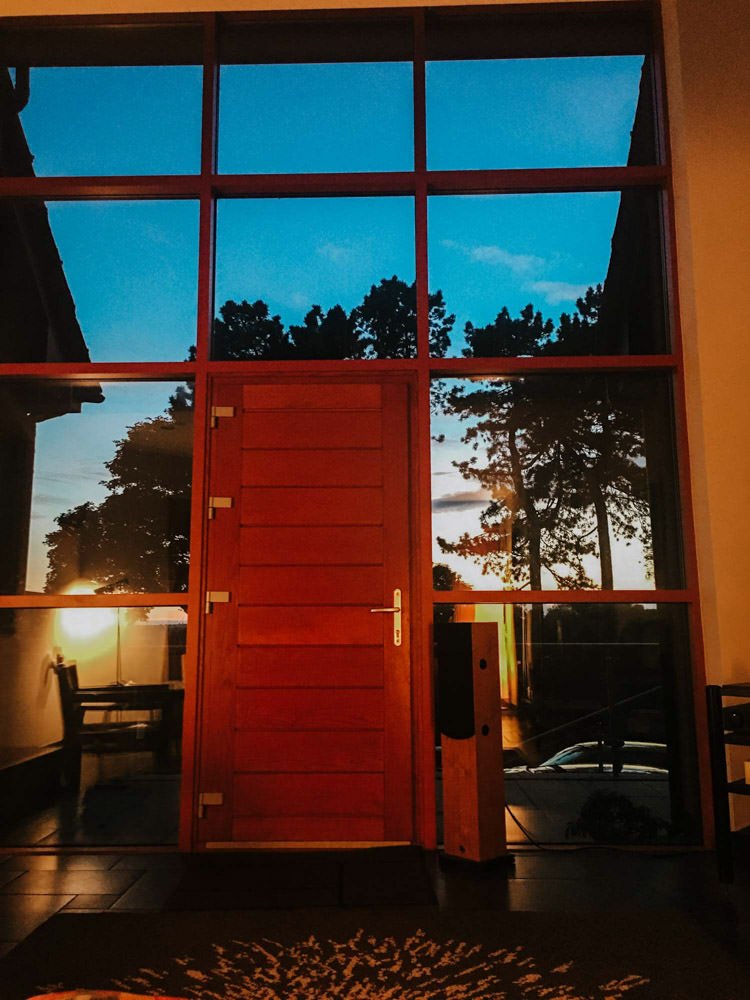 Large wooden door with glass panels, evening outdoor view