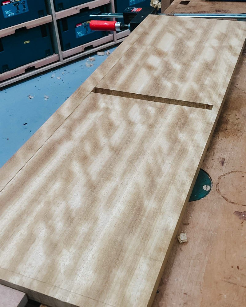 Wooden board with a groove on a workbench in a workshop.