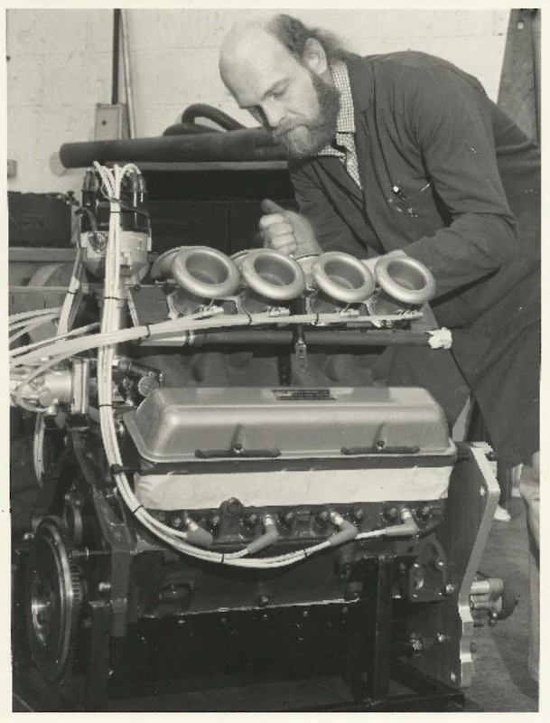 mechanic working on motor black and white photograph