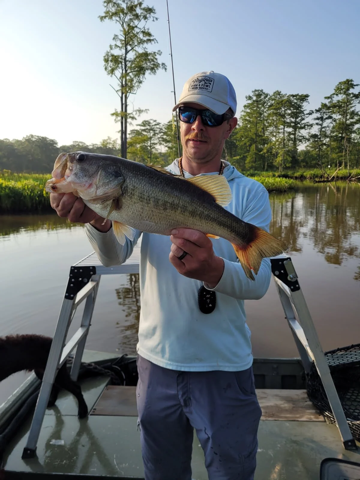 Anglers holding a largemouth bass