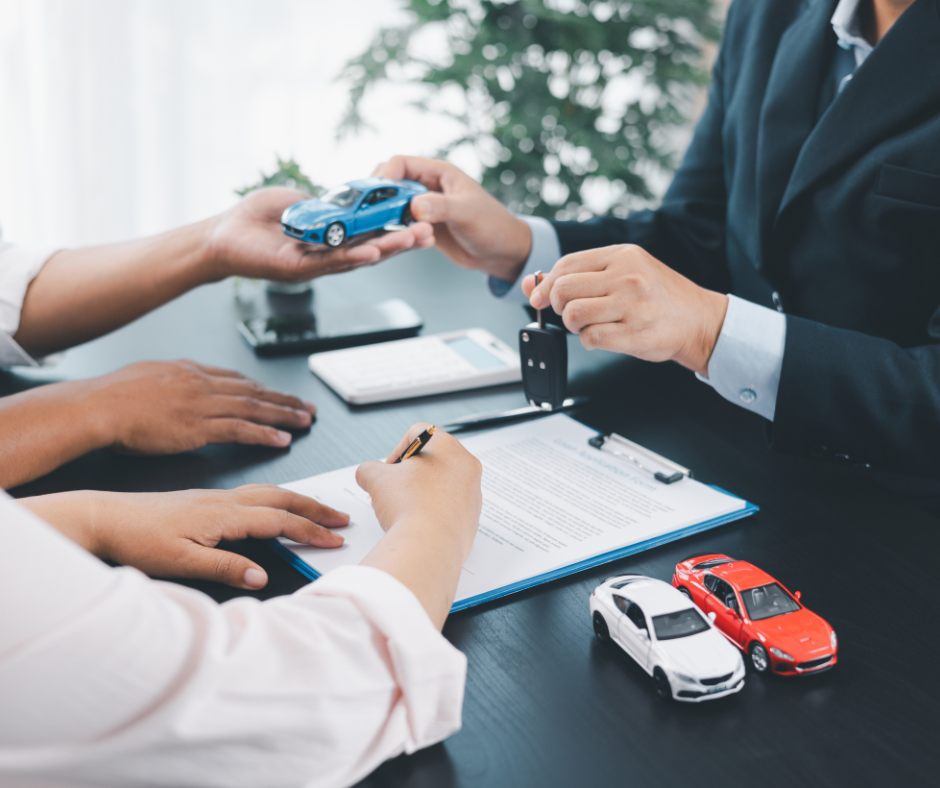 Couple sitting at a desk filling out paper work for an auto loan.