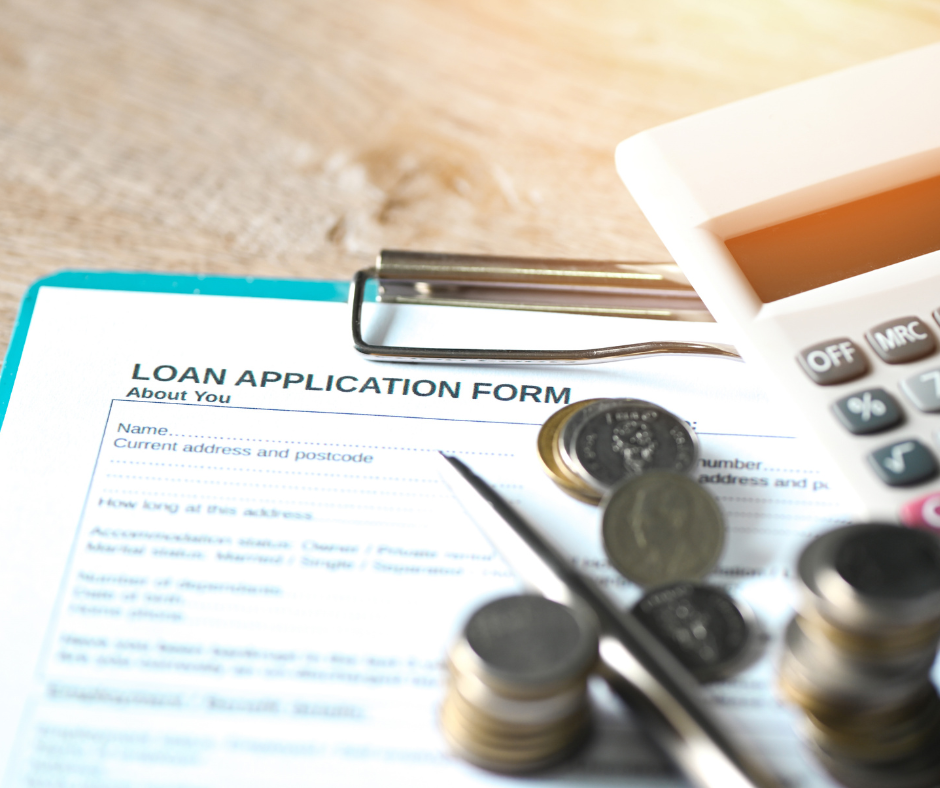 Loan application form with a calculator and some coins.