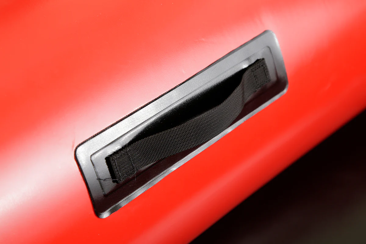 Close-up of a black handle on a red inflatable surface.