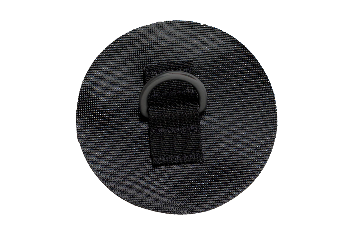 Black circular patch with a strap and D-ring attachment.