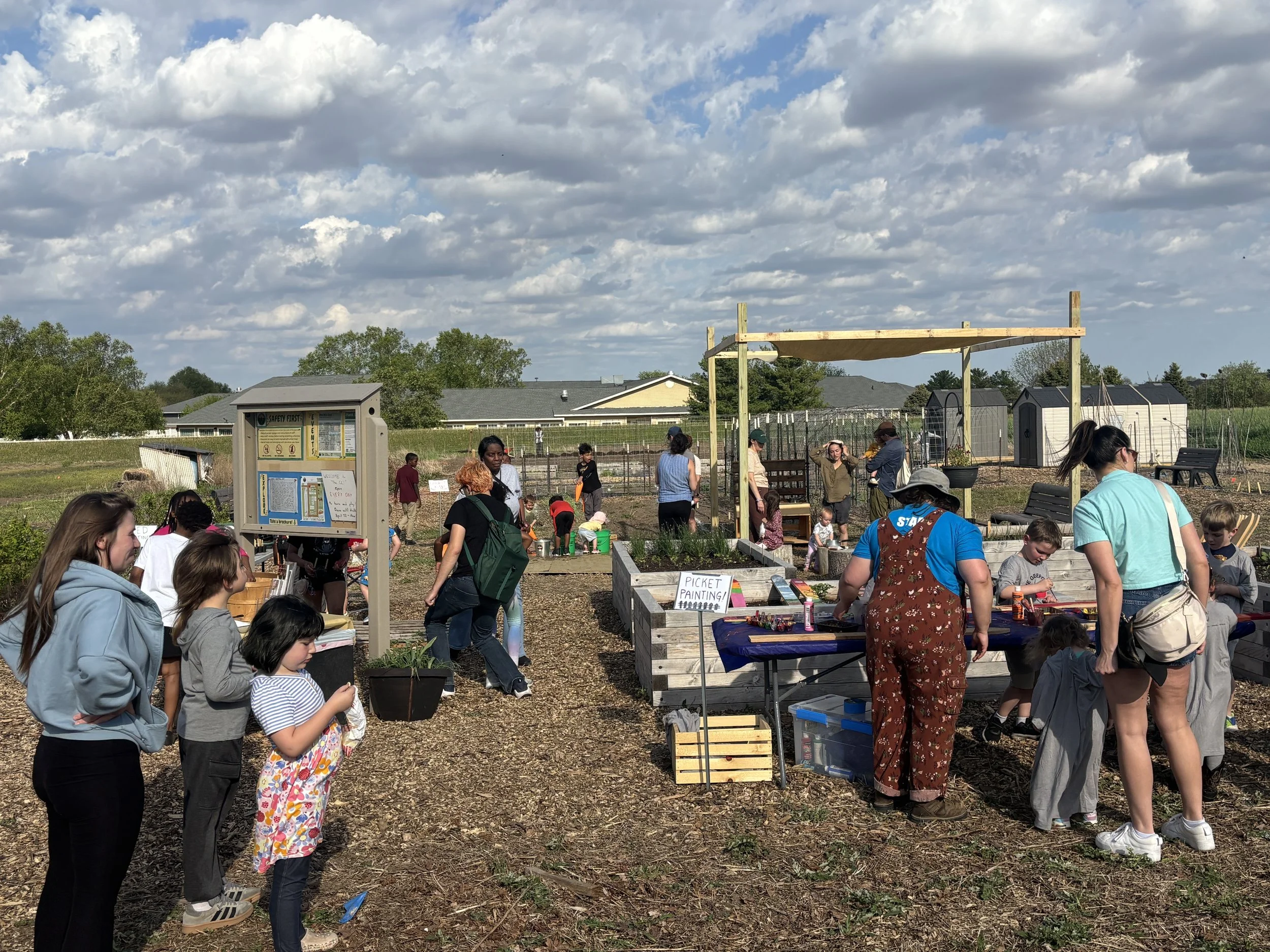 picture of children and adults exploring the gardens and activities at the Community Classroom