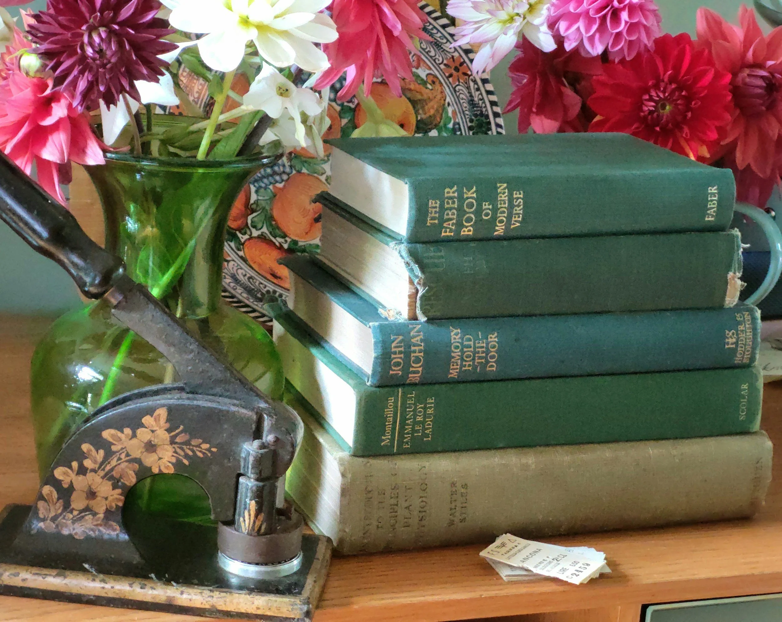Stack of blue books and pink flowers in vase