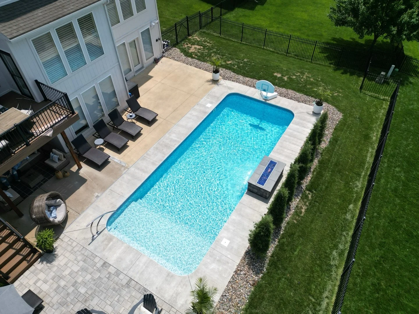 A 14x30 vinyl liner pool with a full width sun deck, gives you plenty of space to actually hang out, not just swim.

Our client chose a Serene Tile liner + Honey Pearl floor to keep the water looking bright and natural, and added a 4&rsquo; waterfall