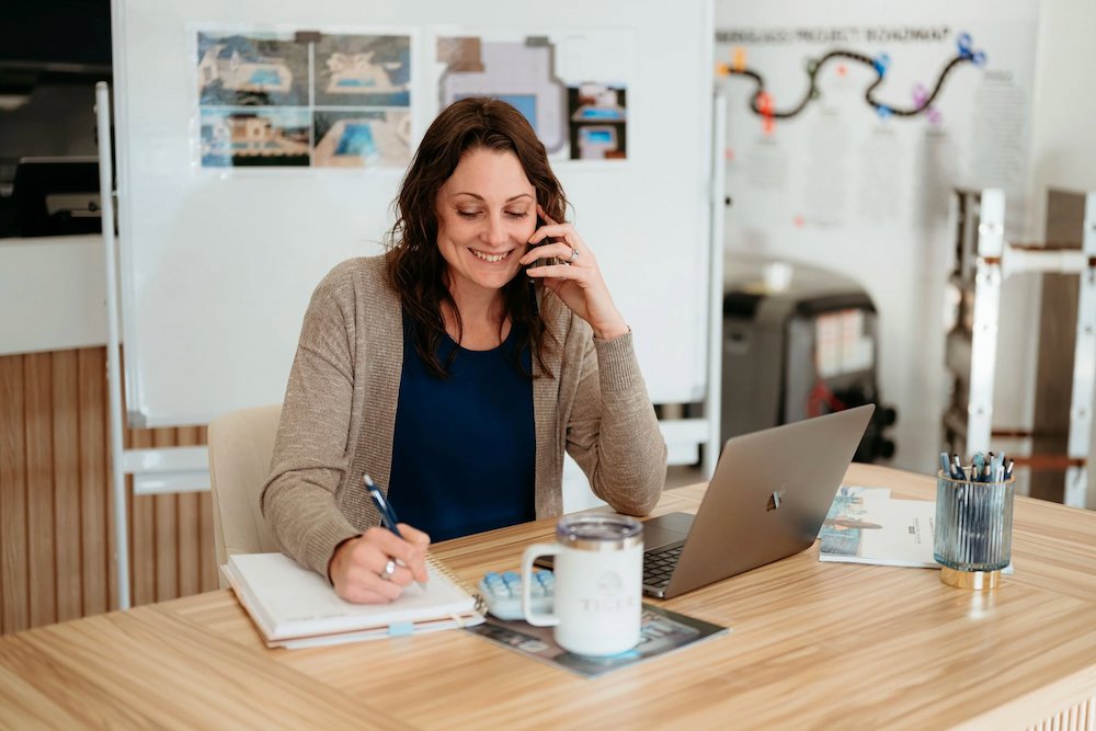 A Tiger Pool and Patio team member taking a customer call to assist with inground pool installation and pool services.