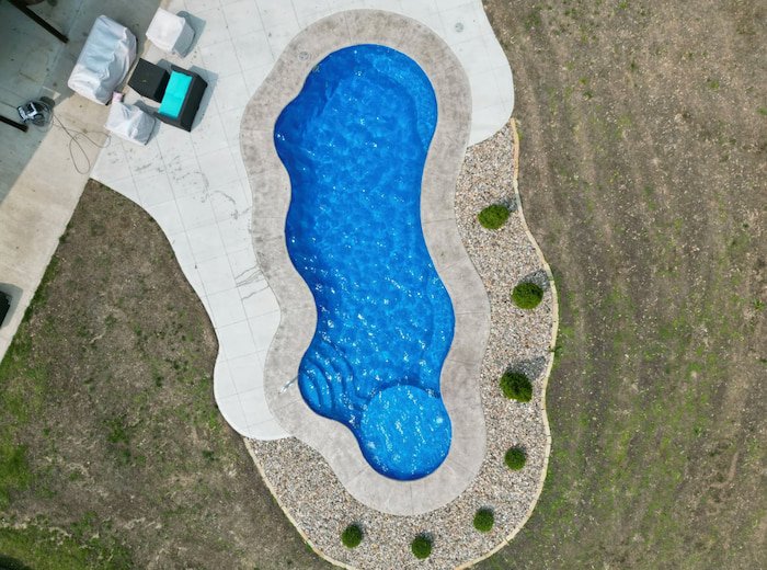 High overhead aerial view of a Thursday Pools Wellspring 16x40 freeform fiberglass inground pool, showcasing the distinctive pool shape installed by Tiger Pool and Patio in Kansas City.