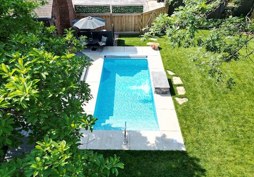 A 10x20 vinyl liner plunge pool with Azure Mosaic liner and water feature wall installed by Tiger Pool and Patio—an ideal small inground pool solution for Kansas City backyards.