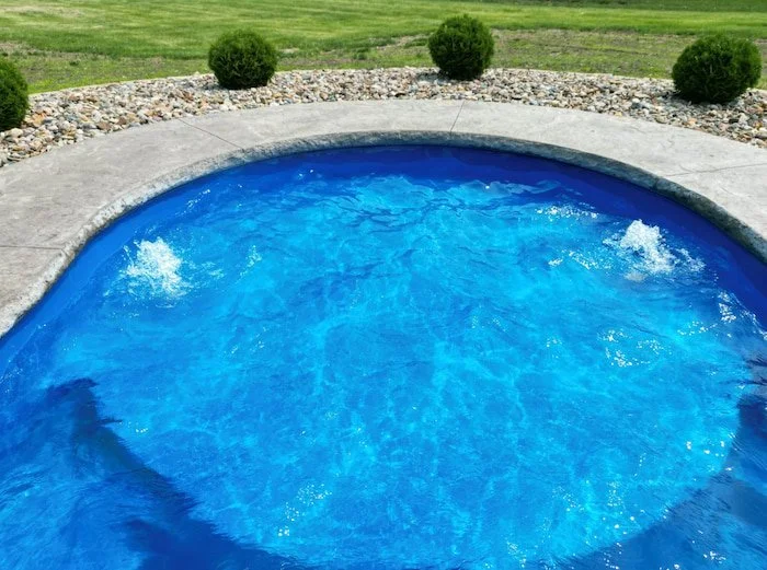 Close-up of active bubblers in the rounded end of a Thursday Pools Wellspring fiberglass inground pool—a fun and functional water feature detail on this Tiger Pool and Patio installation in Kansas City.