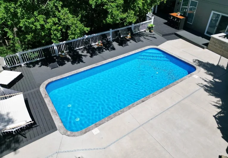 A 14x30 vinyl liner inground pool with Blue Quartz liner, corner steps, and paver patio surround built by Tiger Pool and Patio, a trusted Kansas City vinyl liner pool company.