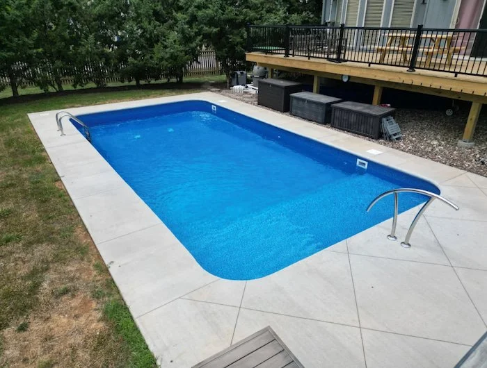 Crystal-clear water showcasing a Jamaica liner pattern with integrated full-length sun deck steps by Tiger Pool and Patio installed in a Kansas City backyard.