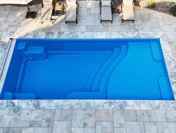 Ground-level view of a fiberglass inground pool installation by Tiger Pool and Patio in Kansas City.