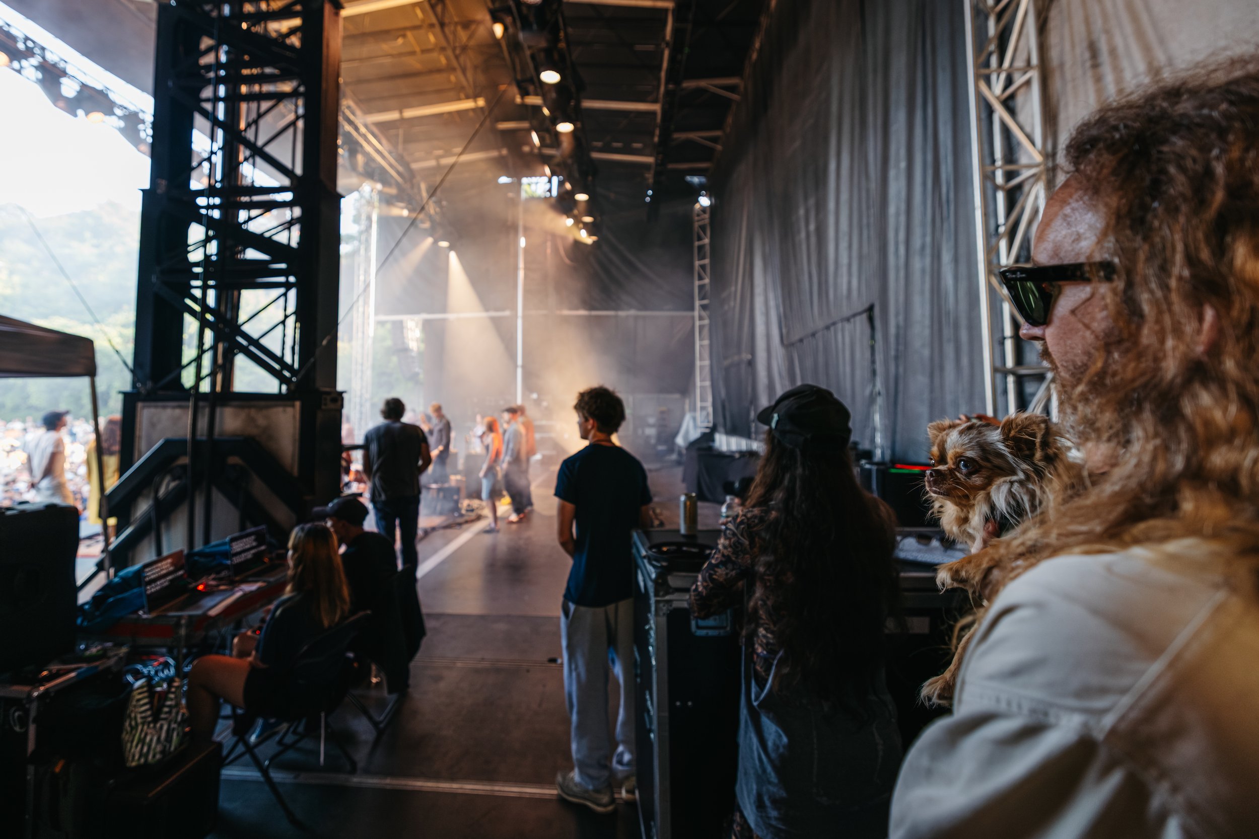 Nick Sanborn of Sylvan Esso holding their dog backstage while watching Wilco perform at the Solid Sound Festival 2026.