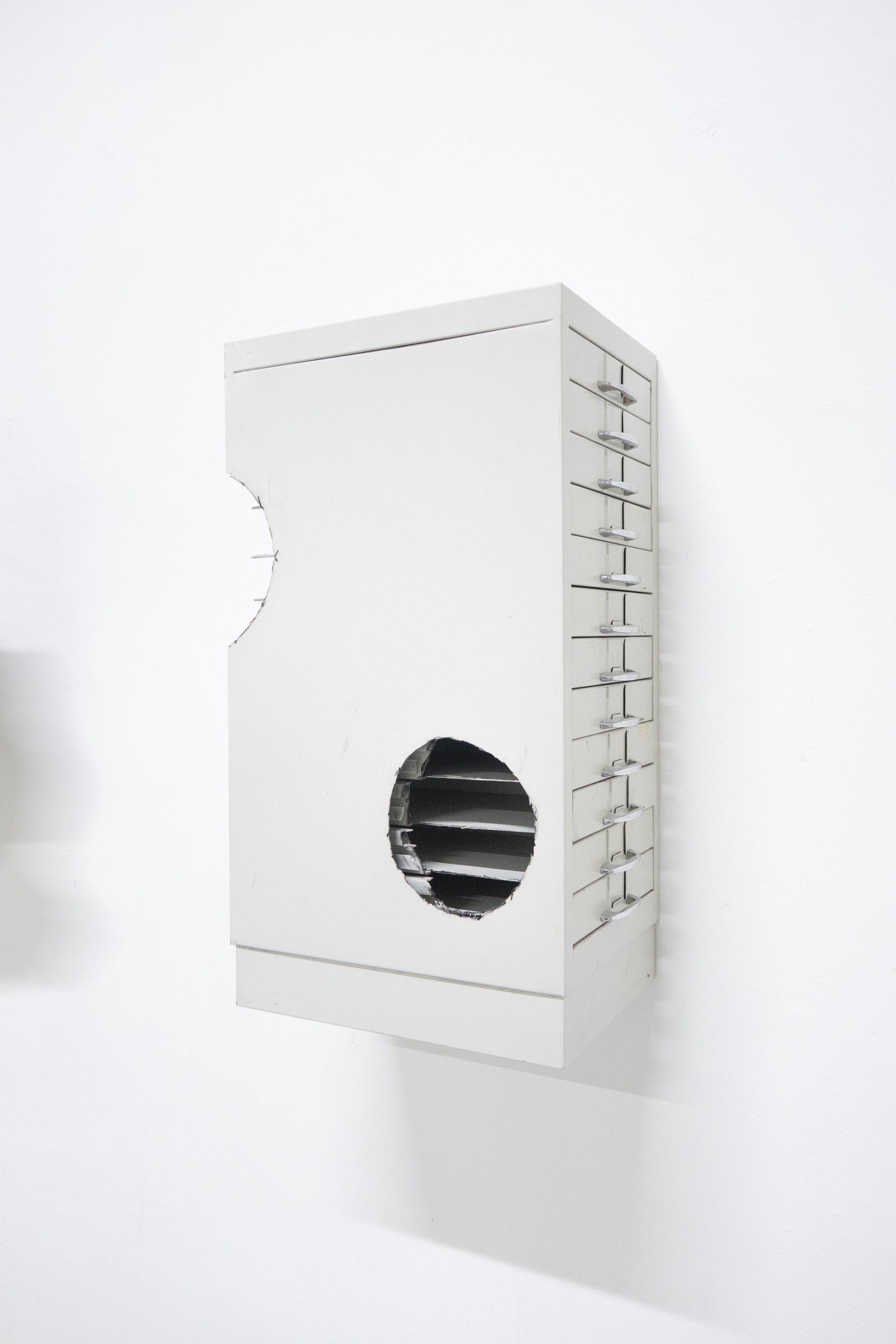 Detail of the metal filing cabinet component of the sculpture “Cabinet,” highlighting its industrial structure and material surface.