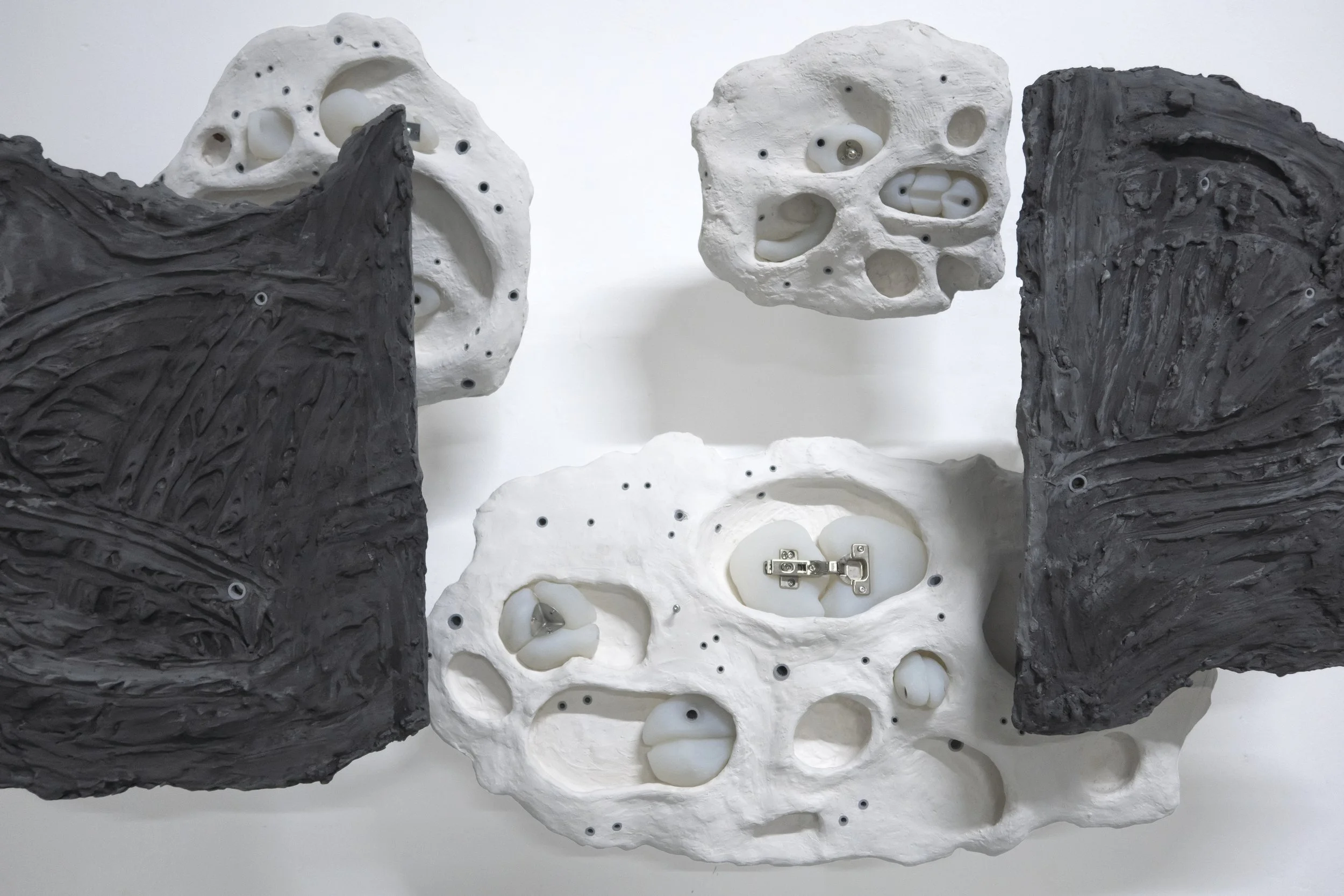 Close-up of the hinges embedded in plaster and silicone within the sculpture “Cabinet,” shown at Loods 6.