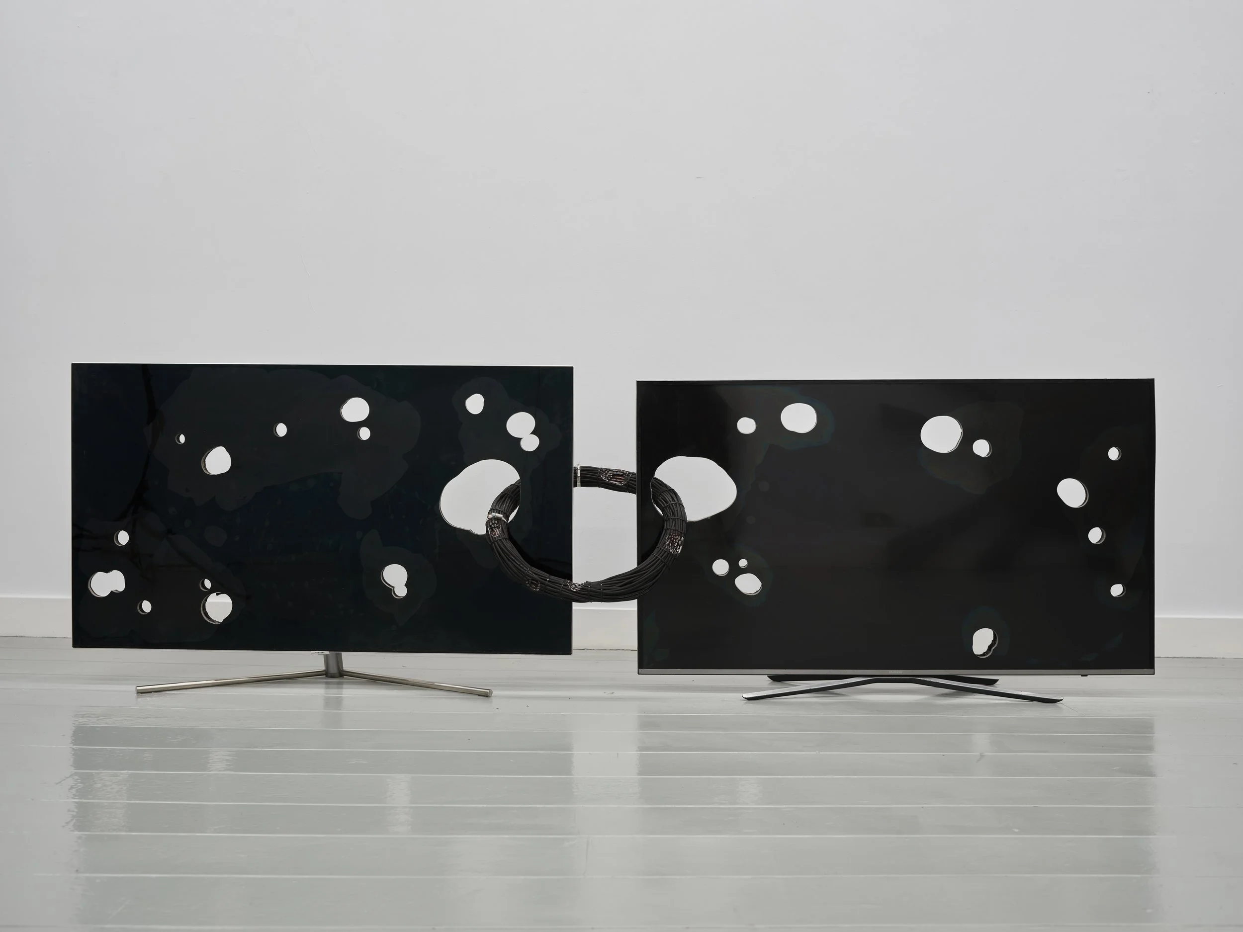 “Orbit,” a sculptural installation composed of perforated TVs and suspended cables, exhibited at Josilda da Conceicao during Amsterdam Art Week and featured in Het Parool.