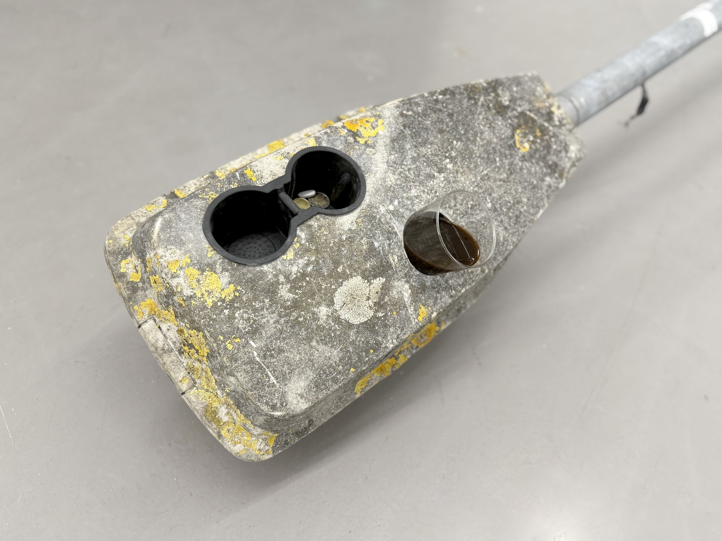 Detail of the coffee glass placed in a metal cupholder integrated into the sculpture “Carving Exchange” at Platform Stockholm.