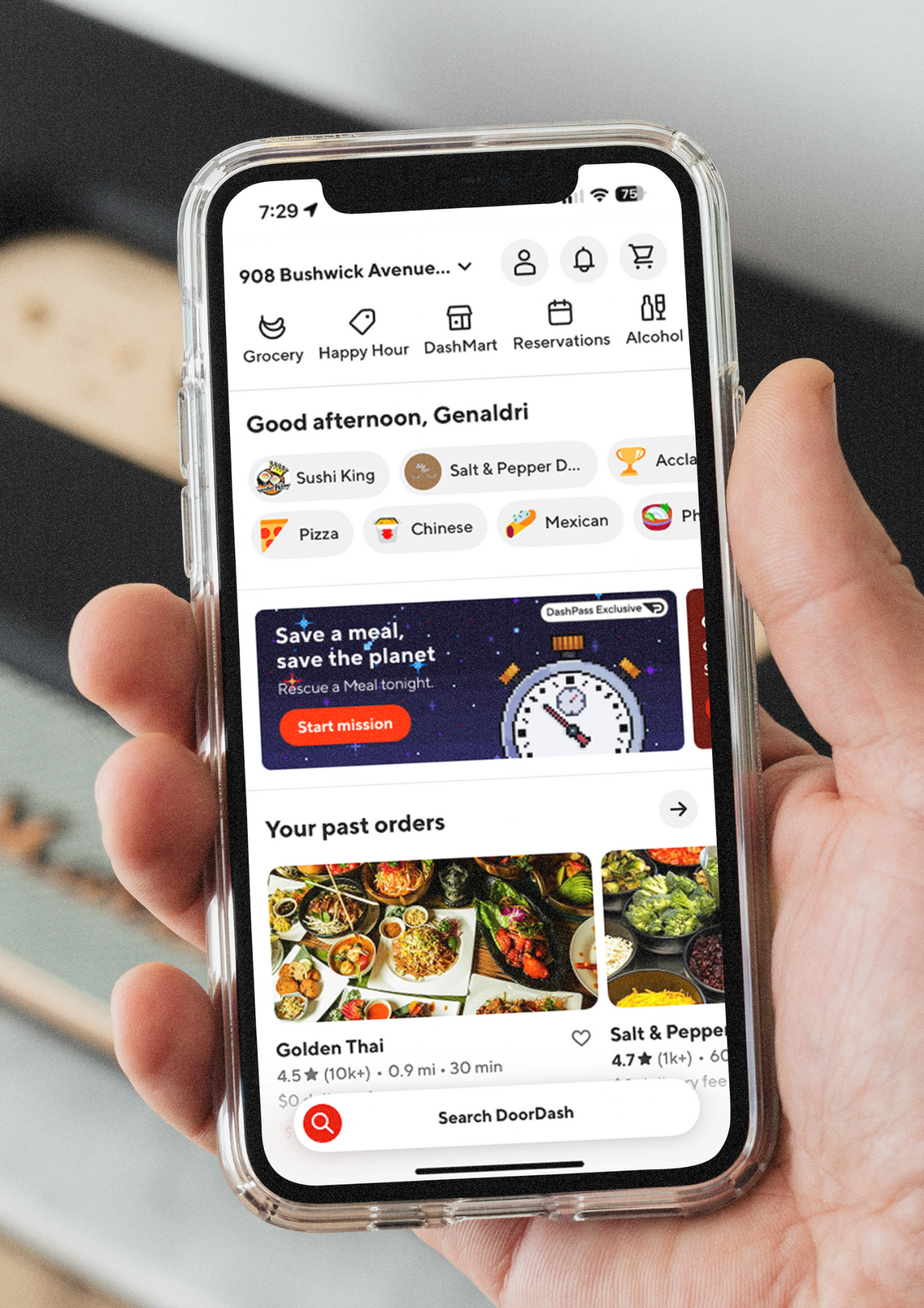A person holding a smartphone displaying the DoorDash app on a home screen.
