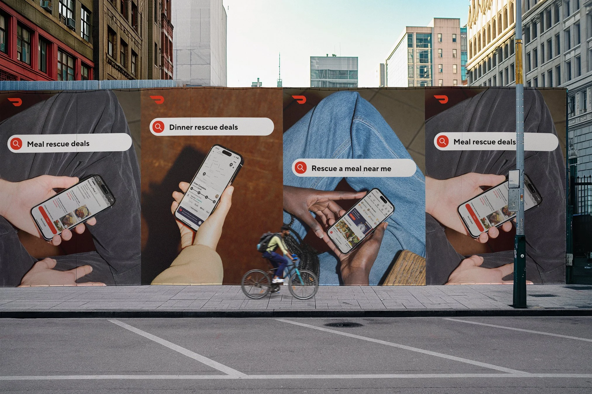 A large billboard advertisement on a city street depicting people using a mobile app for food rescue deals, with search options for meal rescue deals, dinner rescue deals, and nearby meal rescue options. A cyclist passes in front of the billboard.